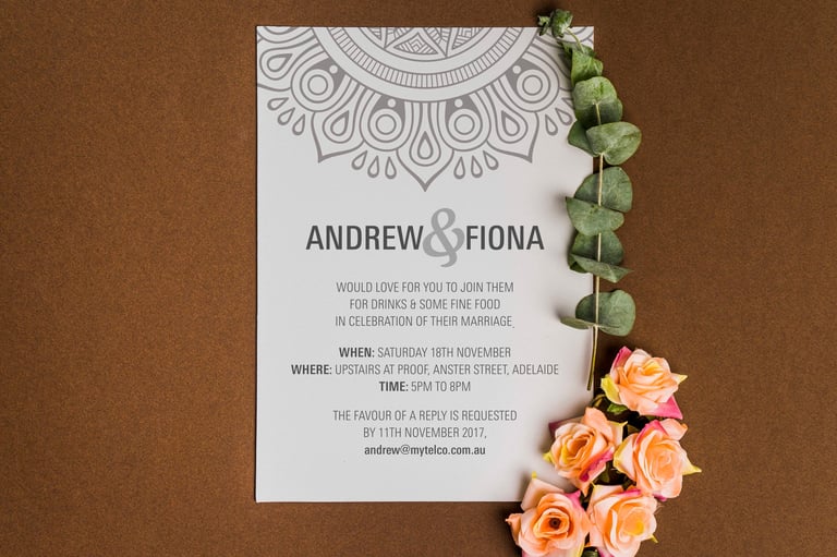 Wedding invitation for Andrew and Fiona decorated with orange roses and greenery on brown background
