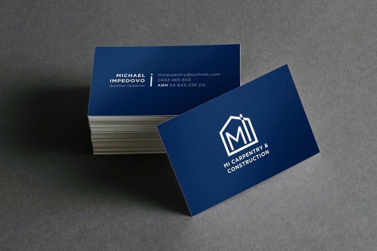 Stack of navy blue business cards with white text and logo, one card displayed at an angle