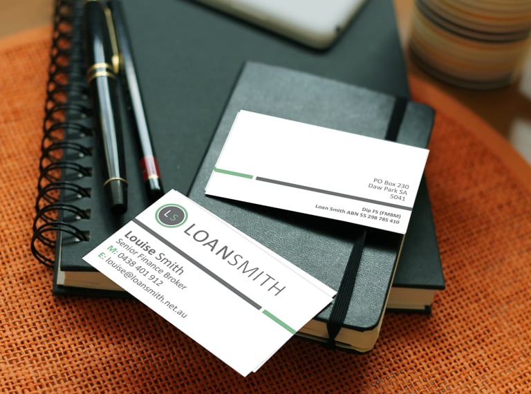 Professional business cards and notebooks arranged on orange fabric with pens and coffee mug