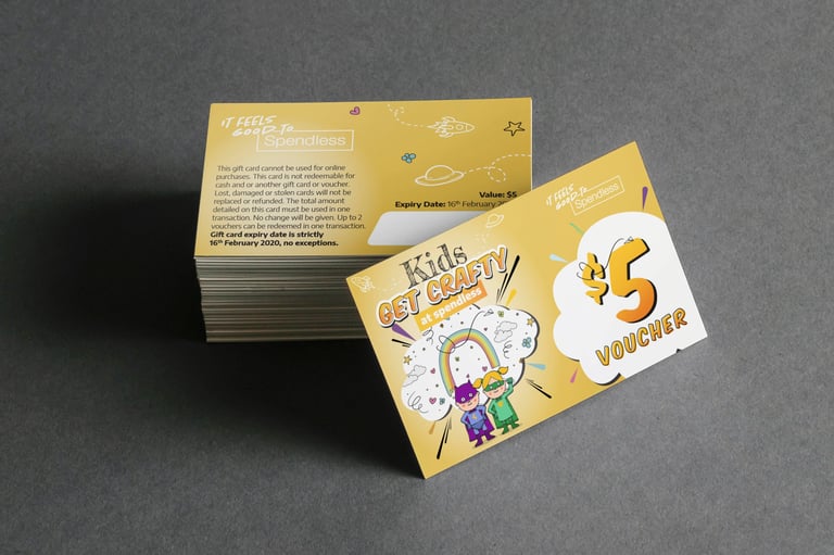 Stack of yellow and white gift cards with space and kids space academy designs displayed at an angle