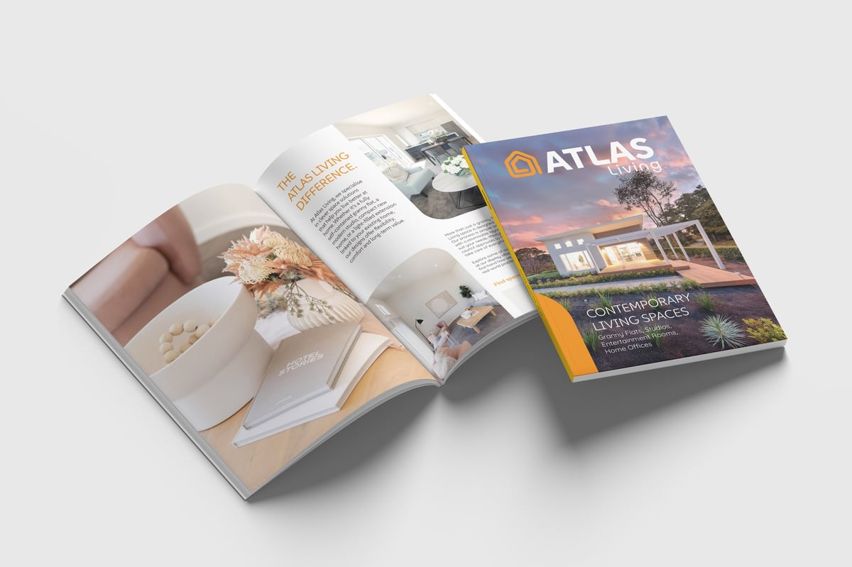 Open magazine displaying interior design content next to ATLAS travel magazine with architectural photography on cover