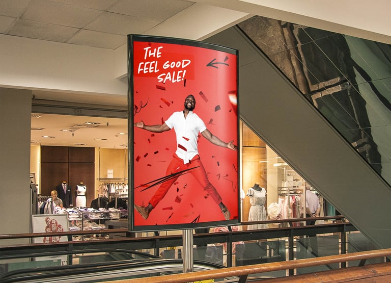 Large red billboard advertisement in mall showing athlete in white shirt jumping, with text THE FEEL GOOD SALE
